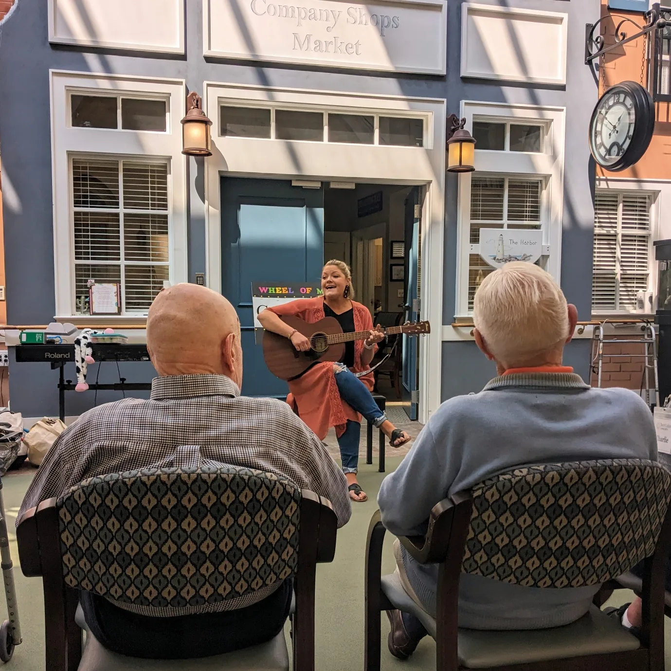 Randi playing guitar and singing for two residents at a senior community